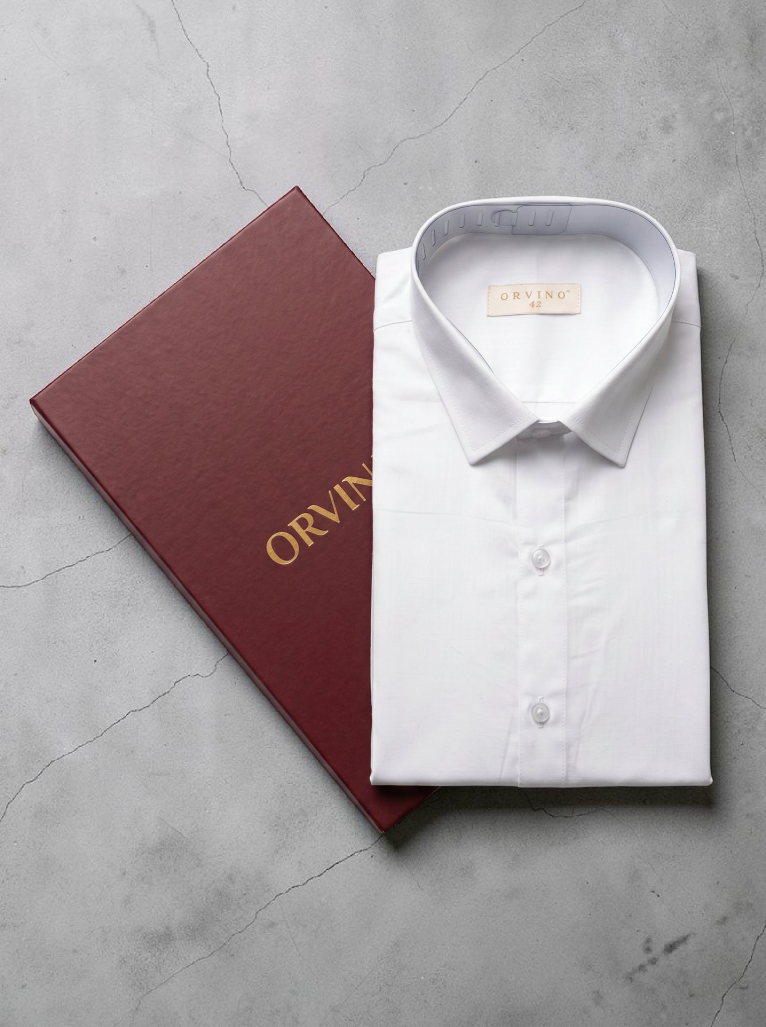 White dress shirt with 'Orvin' branding next to a red box on a gray surface